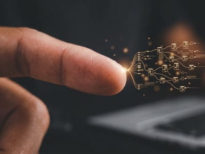 Fingertip touching a glowing network of circuit lines against a dark background